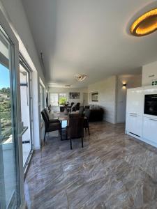 a dining room and living room with a table and chairs at Appartement Ellara Penthouse in Žrnovo