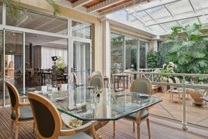 贝热尔莱韦蒂Hostellerie Du Mont Aimé的配有玻璃桌椅的餐厅