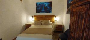 a small bedroom with a bed and two night stands at Casa abuelo Kalinas in Cazorla