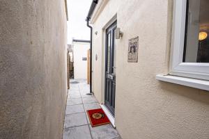 a small alley with a door and a red mat on the ground at Harry Potter Themed Vacation - Sleeps 6 in Leavesden Green