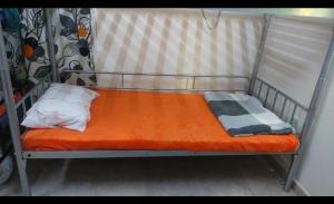a bunk bed with an orange mattress and a pillow at Greens hostel muscat in Muscat