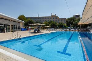 a large swimming pool in front of a building at Ramat Rachel Resort in Jerusalem