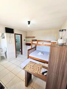 a room with two bunk beds and a table at Casa e Kitnets Imbituba Praia da Vila in Imbituba +112 photos