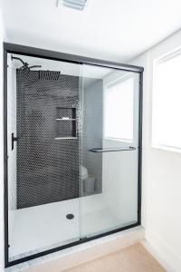 y baño con ducha de cristal y ventana. en Lovely 2br apt, 5 mins drive to the beach - j8, en Hollywood