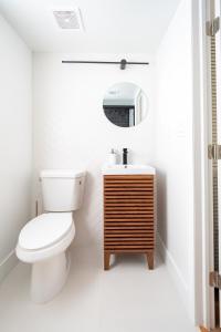 Un baño con inodoro, lavabo y espejo. en Lovely 2br apt, 5 mins drive to the beach - j8, en Hollywood