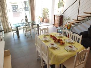 a dining room with a table with a yellow table cloth at Villa Mon Repos Bed & Breakfast in Colera