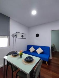 a living room with a blue couch and a table at Benimaclet Habitacion con Baño in Valencia +1 photo