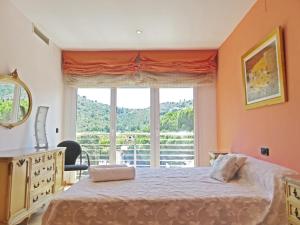 a bedroom with a bed and a large window at Villa Mon Repos Bed & Breakfast in Colera