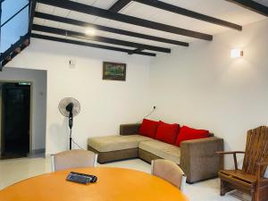 a living room with a couch and a table at Doranagala Holiday Cabin in Rattota