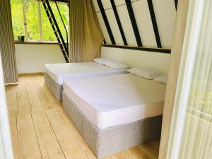 two twin beds in a room with a window at Doranagala Holiday Cabin in Rattota