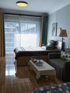 een woonkamer met een bed en een bank bij Vanxing Seaside Residence in Huiyangshi