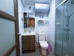een badkamer met douche, toilet en wastafel bij Vanxing Seaside Residence in Huiyangshi