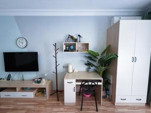 een woonkamer met een bureau en een televisie bij Vanxing Seaside Residence in Huiyangshi +5 foto's