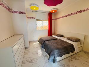 two beds in a room with red curtains at Luxe appartement villa Grand terrasse in Safi