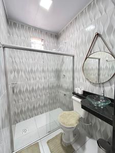 a bathroom with a shower and a toilet and a sink at Loft Marajó in Soure