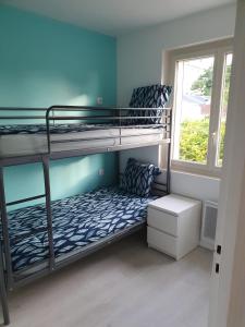 two bunk beds in a room with a window at appartement avec beau jardin in Blois