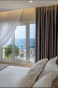 a bedroom with a bed and a view of the ocean at AMI MAR Hotel in Sarandë