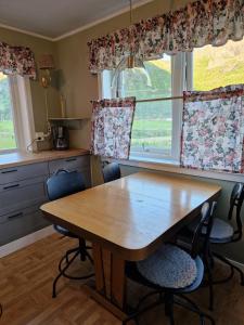 a kitchen with a wooden table and chairs in front of a window at Vareid Panorama Lofoten Lysvollhuset in Vareid +70 photos