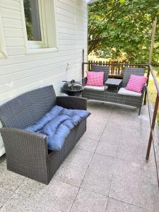 a patio with two wicker chairs with a blue pillow at Chatička u Perniců in Jedovnice +25 photos