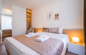 a bedroom with a bed with two towels on it at Evdo Apartments F1 Modern house in Kʼumlistsʼikhe