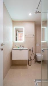 a bathroom with a sink and a toilet and a mirror at Evdo Apartments F1 Modern house in Kʼumlistsʼikhe
