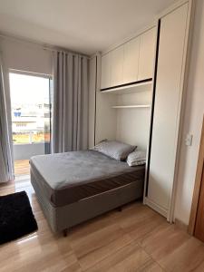 Casa com piscina em Bombinhas في بومبينهاس: غرفة نوم بها سرير ونافذة كبيرة +16 صورة