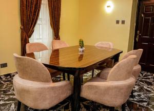 a conference room with a wooden table and chairs at Austin's Apartment in Port Harcourt