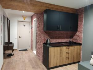 une cuisine avec un comptoir noir et un mur de briques dans l'établissement Evdo Apartments F4 modern room, à Kʼumlistsʼikhe