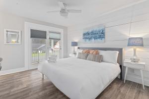 Coastal Haven 5 mins to Beach 15 mins to dtwn في تشارلستون: غرفة نوم بيضاء مع سرير أبيض ونافذة