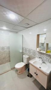 a bathroom with a toilet and a sink and a mirror at Wadi Rum Oday Luxury Camp in Wadi Rum
