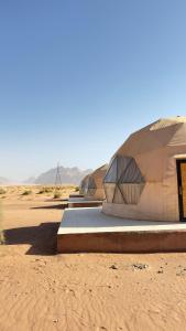 a group of domed buildings in the desert at Wadi Rum Oday Luxury Camp in Wadi Rum