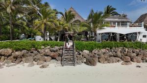 a person standing on a ladder on the beach at Casa Paradis Boutique Hotel in Jambiani
