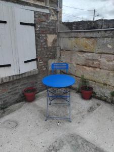 a blue table with a blue chair in front of a building at Le petit Liancourtois, 1 bedroom in Liancourt +1 photo