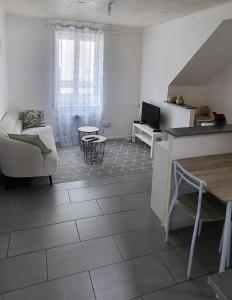 a white living room with a couch and a table at Le petit Liancourtois, 1 bedroom in Liancourt