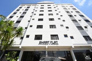 Un edificio blanco con un cartel en él. en SMART FLAT HOTEL apartamento 11A CENTRO, en Mogi das Cruzes