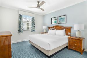 a white bedroom with a bed and a ceiling fan at Hilton Vacation Club Grand Beach Orlando in Orlando +70 photos