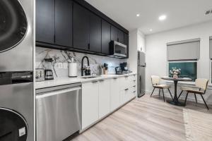 a kitchen with white cabinets and a table with chairs at Japandi Style 1BR Escape w EV Charger, Bishop Arts in Oak Cliff