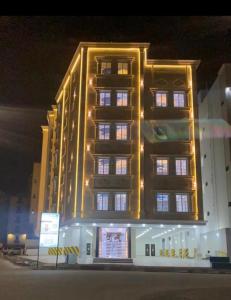 un edificio alto con luces encendidas por la noche en شقة جديدة ديكور فخم مدخل ذكي, en Taif 105 fotos más