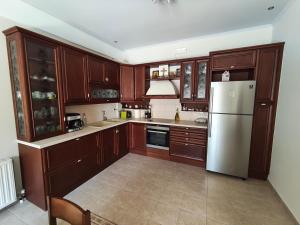 a kitchen with wooden cabinets and a white refrigerator at Villa Sotiriou in Limne