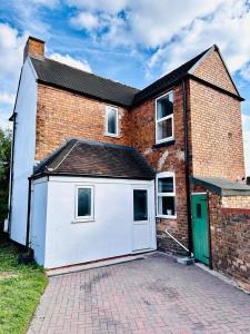 Willenhallにある#56 Stylish 4-Bed House Free Parking Near Shopsの白いガレージ付きの大きなレンガ造りの家