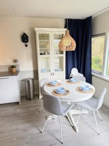 mesa de comedor con sillas y lámpara de araña en Appartement Duinoord, Zoutelande, en Zoutelande