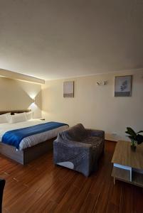 a hotel room with a bed and a chair at Hotel Asia Pacifico in Santiago