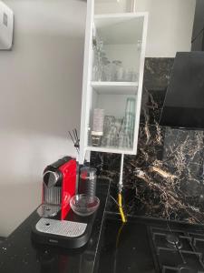 a kitchen counter with a coffee maker and a cupboard at Elegant Apartment for a Peaceful Stay in Tunis