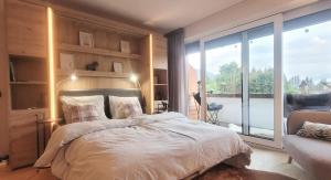 a bedroom with a bed and a large window at ALPartement Seefeld in Seefeld in Tirol