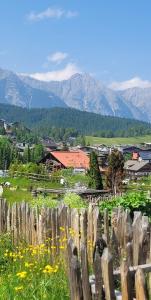 a fence in a field with mountains in the background at ALPartement Seefeld in Seefeld in Tirol