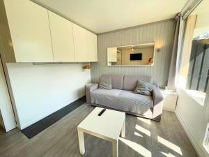a living room with a couch and a table at Résidence Villaret - Studio cabine avec cuisiné équipée et vue sur les pistes MAE-4194 in Les Menuires +11 photos