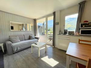 a living room with a couch and a table at Résidence Villaret - Studio cabine avec cuisiné équipée et vue sur les pistes MAE-4194 in Les Menuires