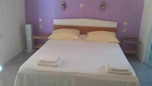 a bedroom with a white bed with two towels on it at Apartments Antica in Šimuni