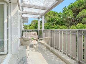 a porch with chairs and a pergola at L'appartement près de la source in Mimizan-Plage