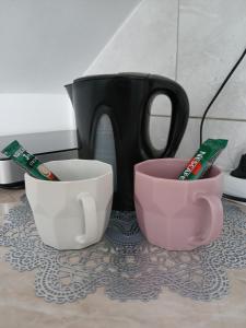 Tres tazas y cepillos de dientes están sobre un mostrador. en Studio Mina, en Soko Banja 9 fotos más